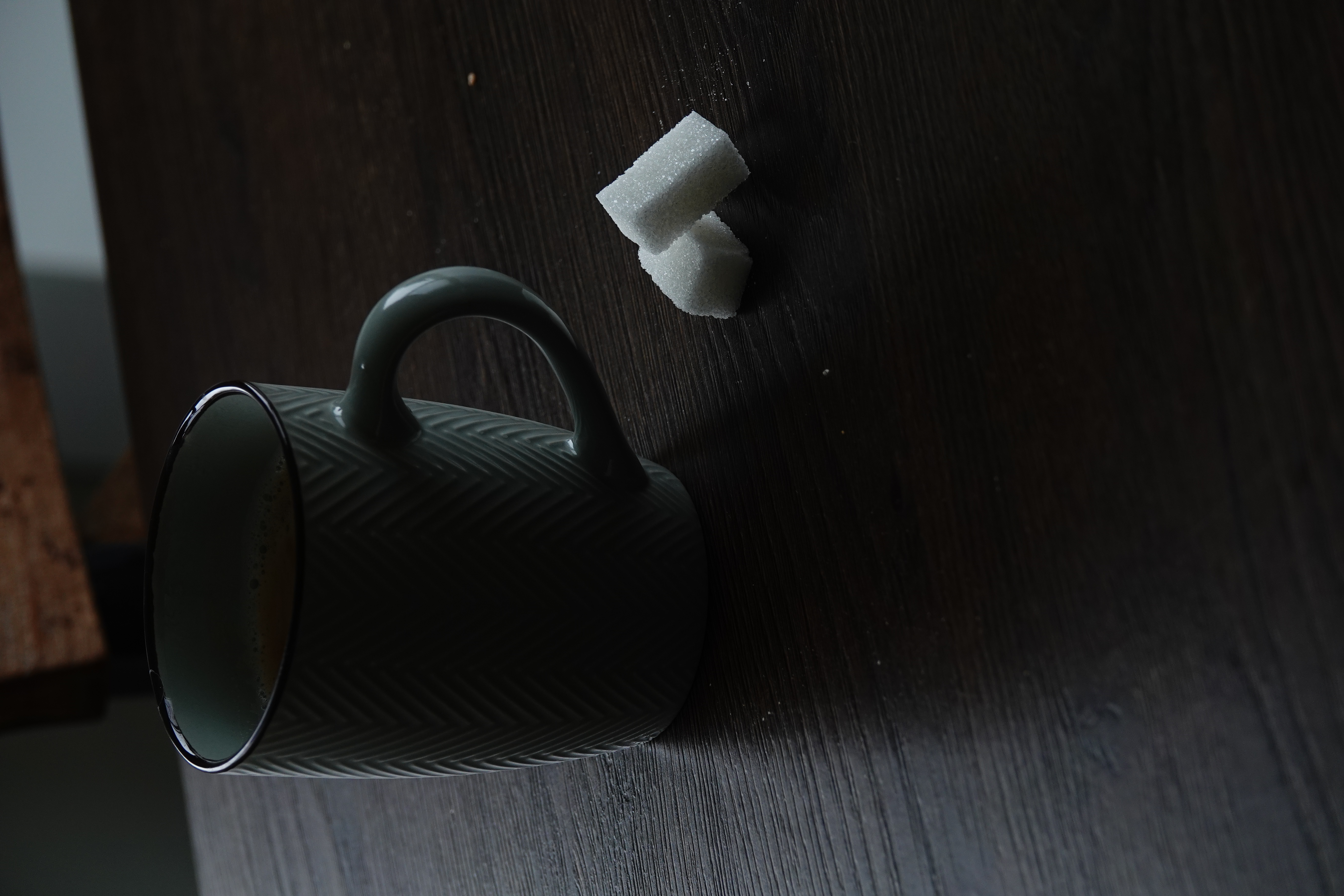 Kop koffie met suikerklontjes op donker hout